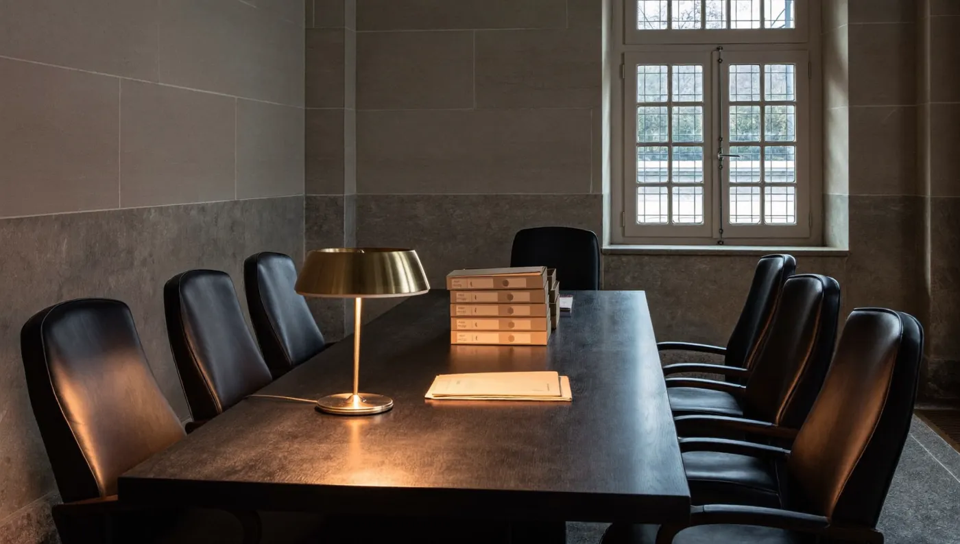 Limestone claims-review room with a long dark table and evidence files.